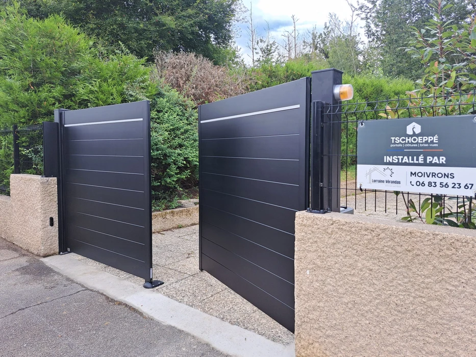 Entrée résidentielle extérieure avec portail battant automatisé anthracite