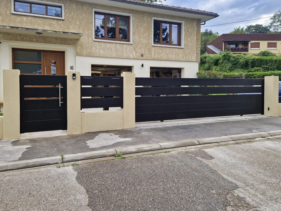 Portail coulissant automatique résidentiel avec portillon piéton intégré, installé devant maison contemporaine