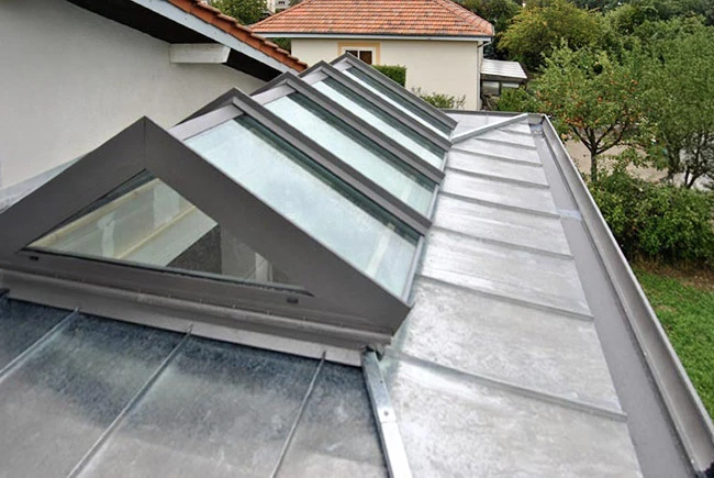 Toiture moderne avec verrières inclinées et structure métallique grise