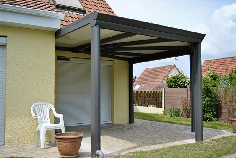 Portail d'entrée résidentiel extérieur avec deux vantaux en aluminium gris anthracite, piliers en blocs béton beige, clôture assortie