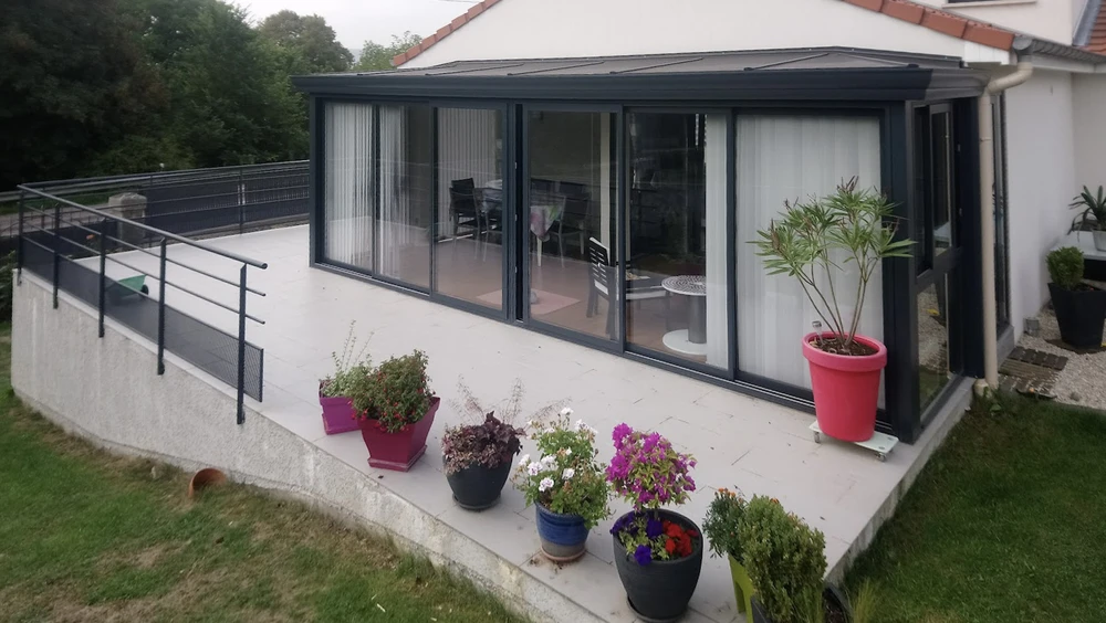 Toit en tuiles terre cuite avec installation de fenêtres de toit et verrière sur charpente résidentielle